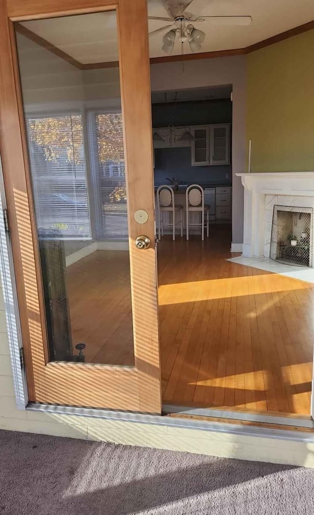 interior space featuring crown molding, a fireplace, and ceiling fan