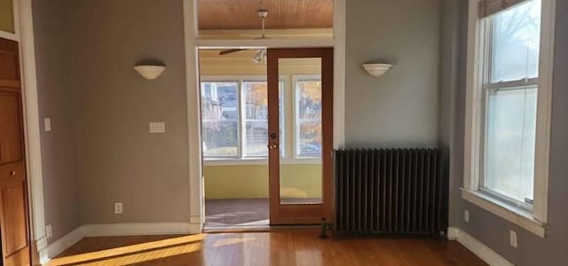 doorway to outside with hardwood / wood-style flooring and radiator