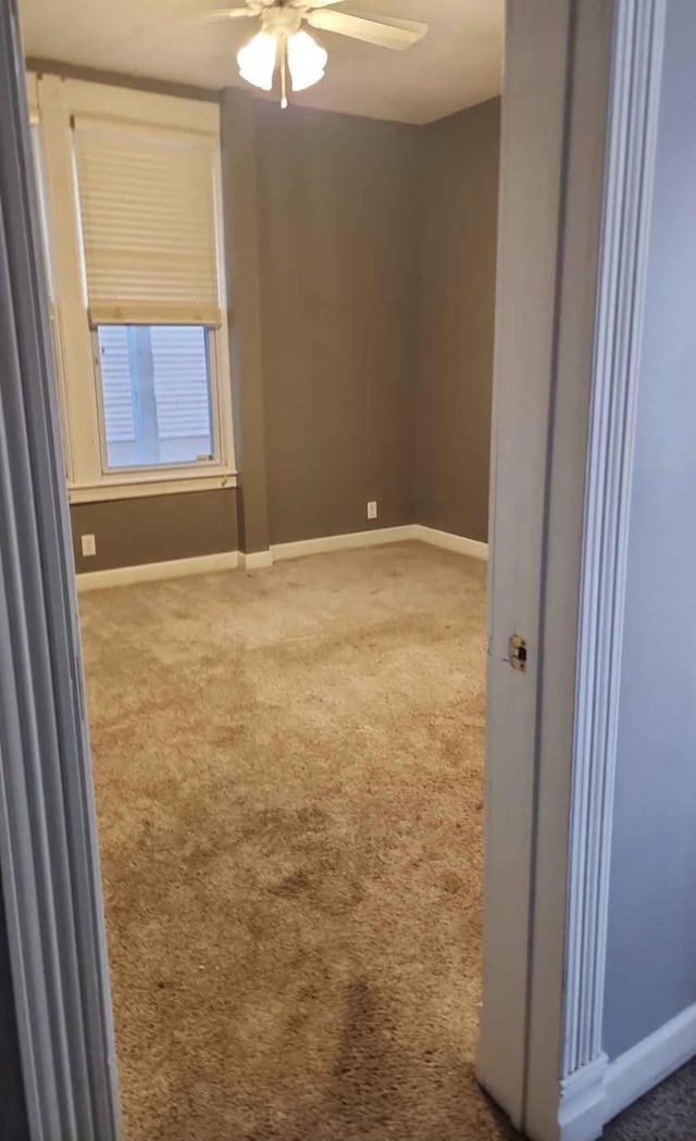 empty room with ceiling fan and carpet