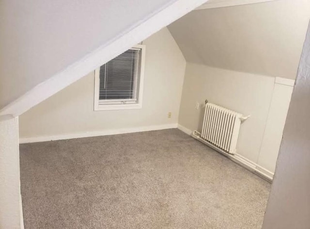 bonus room featuring vaulted ceiling, carpet, and radiator heating unit