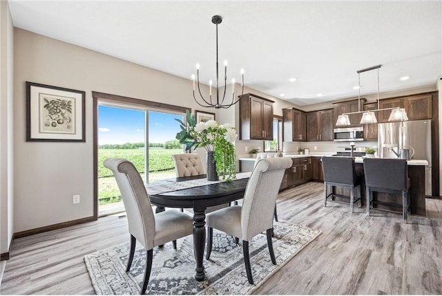 dining room with light hardwood / wood-style flooring and a chandelier