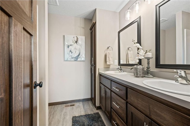 bathroom with vanity, hardwood / wood-style floors, and a textured ceiling