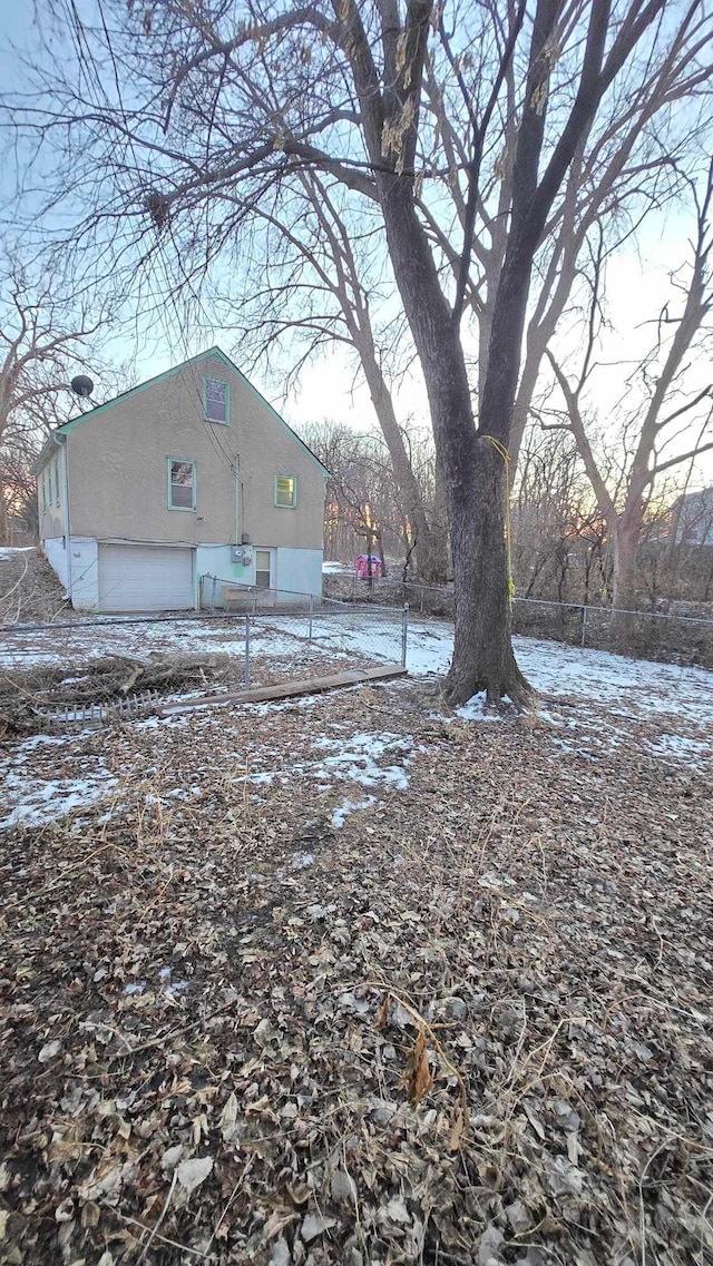 yard layered in snow featuring a garage