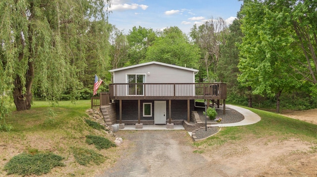 1524 Mulberry St, Taylors Falls, MN 55084 - view of front facade featuring a deck, a patio, a front lawn, and driveway