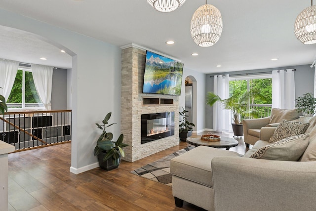 1524 Mulberry St, Taylors Falls, MN 55084 - living area featuring arched walkways, a fireplace, a chandelier, baseboards, and wood finished floors