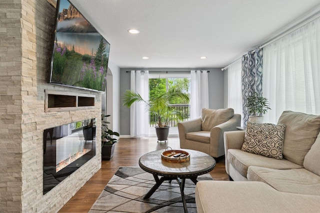 1524 Mulberry St, Taylors Falls, MN 55084 - living room featuring a stone fireplace, dark wood-style floors, recessed lighting, and baseboards