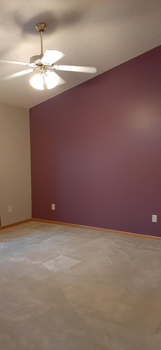 carpeted empty room with ceiling fan and a textured ceiling