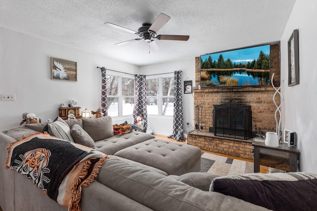 living room with a brick fireplace, a textured ceiling, and ceiling fan