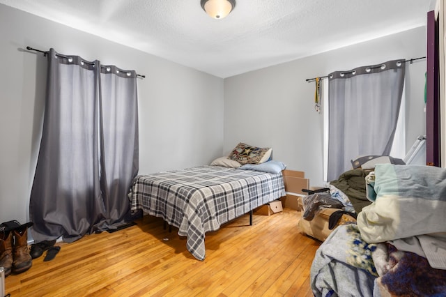 bedroom featuring hardwood / wood-style flooring and a textured ceiling