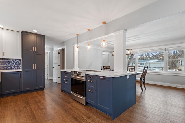 kitchen with dark hardwood / wood-style floors, pendant lighting, blue cabinets, tasteful backsplash, and stainless steel range with electric cooktop