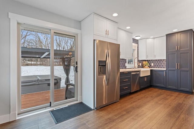 kitchen featuring stainless steel appliances, gray cabinets, and white cabinets