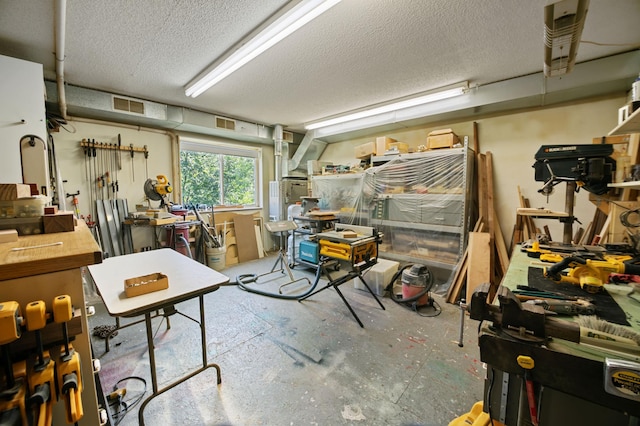 basement featuring a workshop area and a textured ceiling