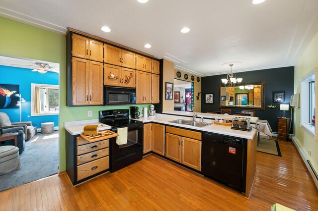 304 Main St S, Saint Michael, MN 55376 - kitchen with black appliances, a sink, a peninsula, a chandelier, and light countertops