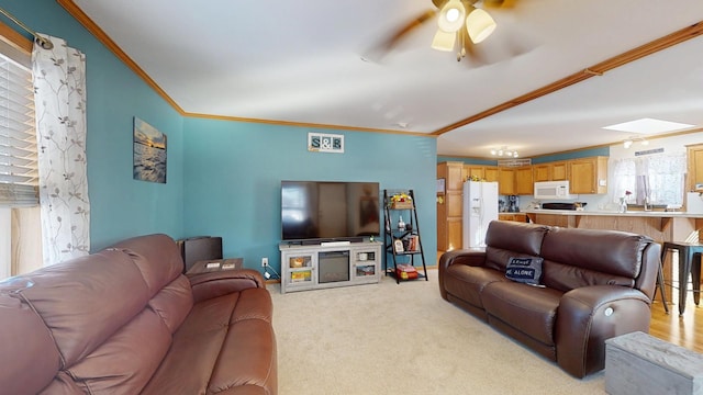 living room with ornamental molding, light colored carpet, baseboards, and a ceiling fan