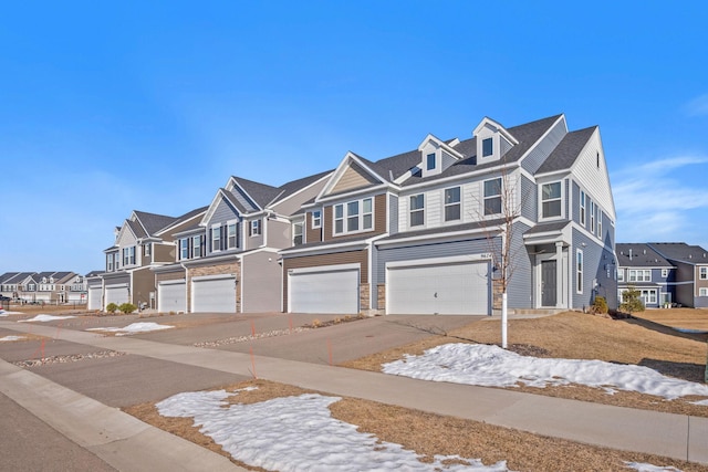 townhome / multi-family property featuring a residential view, concrete driveway, and a garage