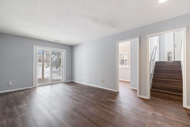 spare room featuring dark hardwood / wood-style flooring and a textured ceiling