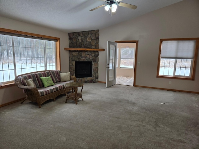 living room with vaulted ceiling, light carpet, a textured ceiling, ceiling fan, and a fireplace