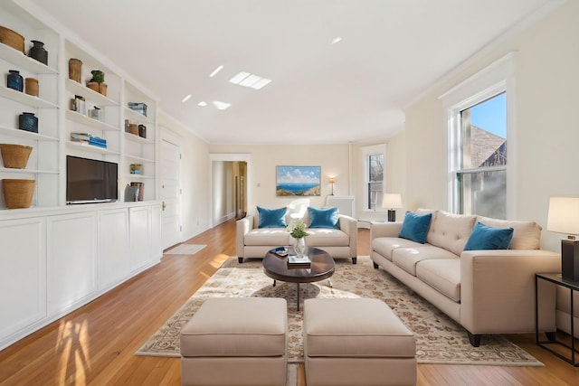 living room with light hardwood / wood-style flooring and ornamental molding