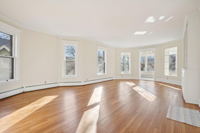 unfurnished room featuring hardwood / wood-style floors, a baseboard radiator, ornamental molding, and a healthy amount of sunlight