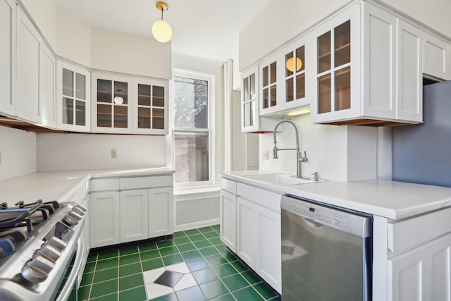 kitchen with sink, decorative light fixtures, appliances with stainless steel finishes, dark tile patterned flooring, and white cabinets