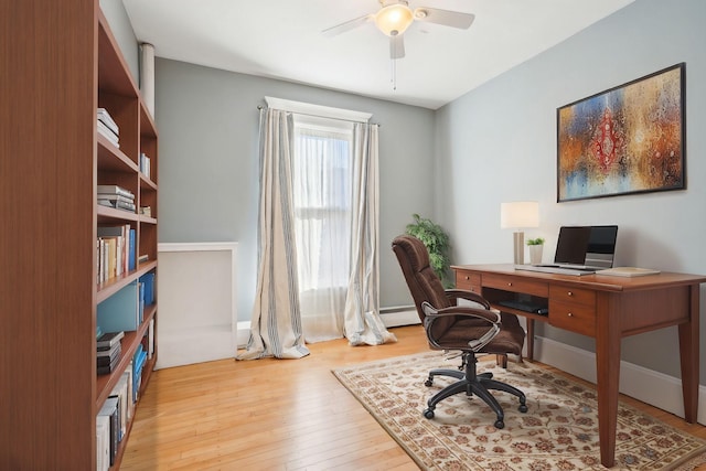 home office featuring ceiling fan, a baseboard radiator, and light hardwood / wood-style flooring