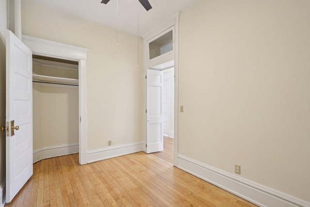 unfurnished bedroom with wood-type flooring, ceiling fan, and a closet