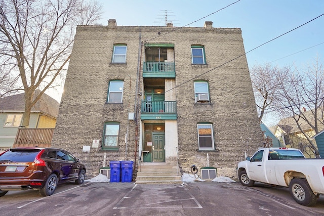 view of property with uncovered parking and central AC