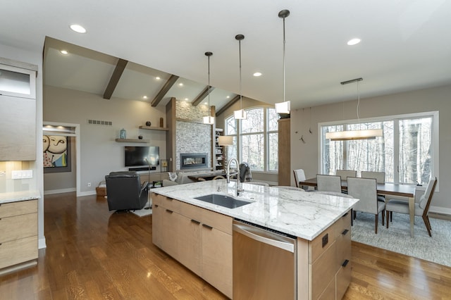 kitchen with visible vents, light brown cabinetry, a sink, stainless steel dishwasher, and dark wood finished floors