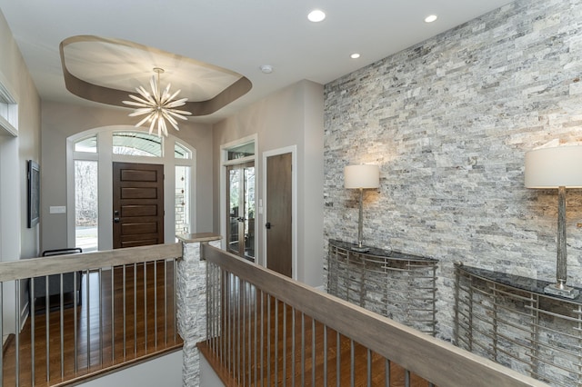 entrance foyer with recessed lighting, a healthy amount of sunlight, and a tray ceiling