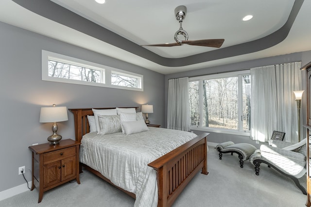 bedroom featuring recessed lighting, baseboards, light colored carpet, and a raised ceiling