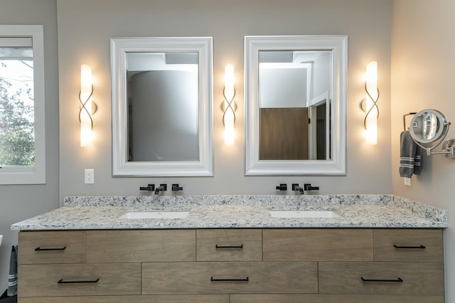 full bathroom with a sink and double vanity