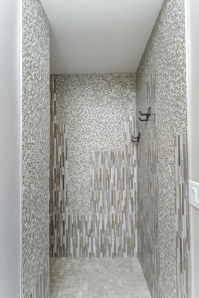 interior space featuring a tile shower and a textured ceiling