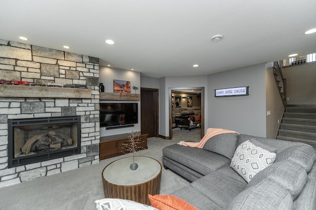 living room featuring recessed lighting, stairway, a stone fireplace, and carpet flooring