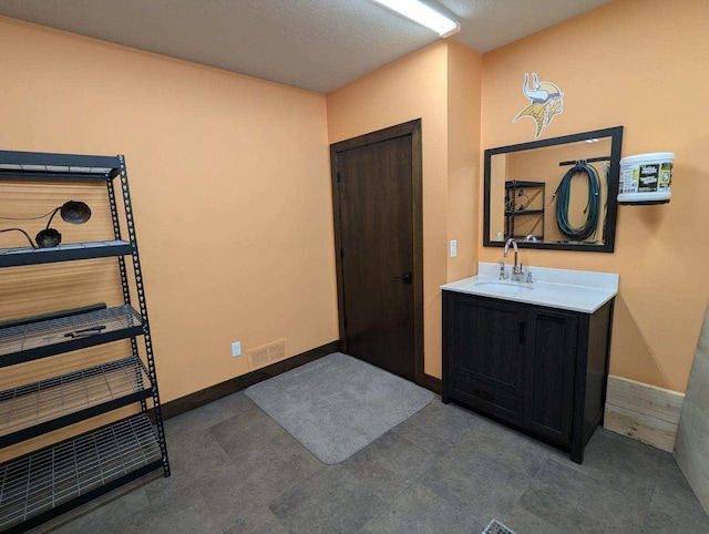 bathroom featuring visible vents, vanity, and baseboards