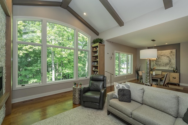 living room featuring visible vents, baseboards, wood finished floors, and vaulted ceiling with beams