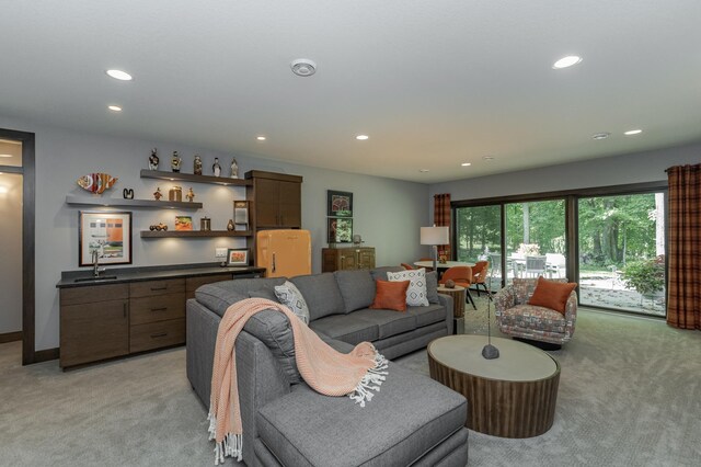 living room featuring a bar, recessed lighting, baseboards, and light carpet