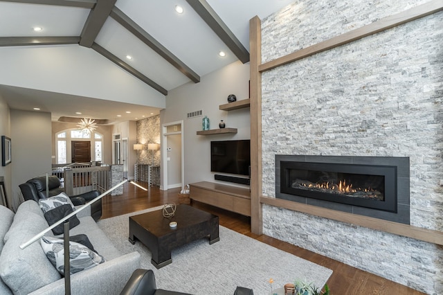 living room featuring wood finished floors, high vaulted ceiling, a fireplace, beamed ceiling, and baseboards