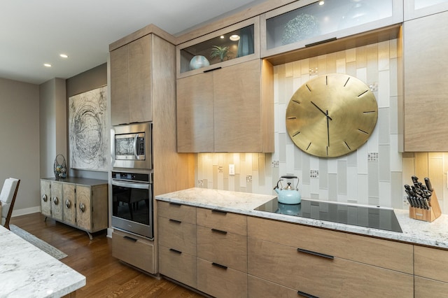 kitchen with stainless steel appliances, dark wood finished floors, light stone countertops, backsplash, and glass insert cabinets