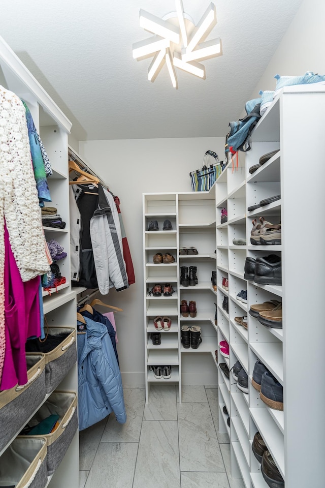 spacious closet featuring light marble finish floors