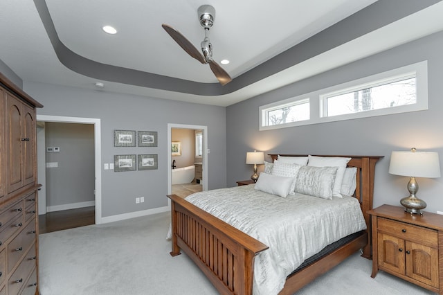 bedroom featuring light colored carpet, recessed lighting, baseboards, ensuite bath, and ceiling fan