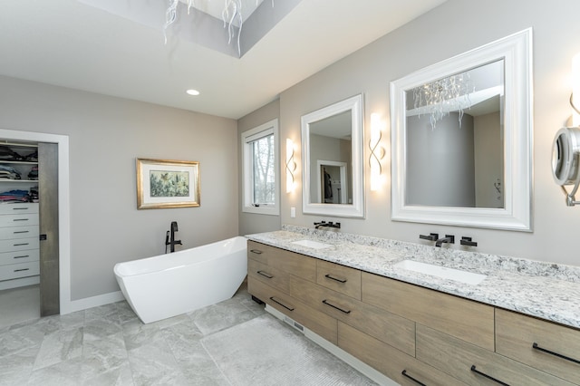 bathroom featuring double vanity, a soaking tub, a spacious closet, marble look tile flooring, and recessed lighting