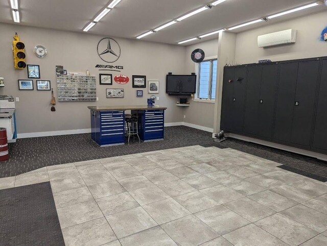 garage featuring a wall unit AC and baseboards