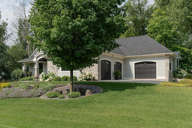 view of front of home featuring an attached garage, a front yard, roof with shingles, and stone siding