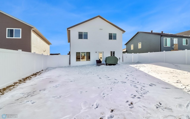 view of snow covered back of property