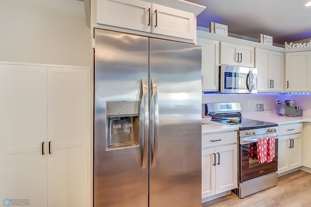 kitchen featuring light wood-type flooring, white cabinets, and appliances with stainless steel finishes