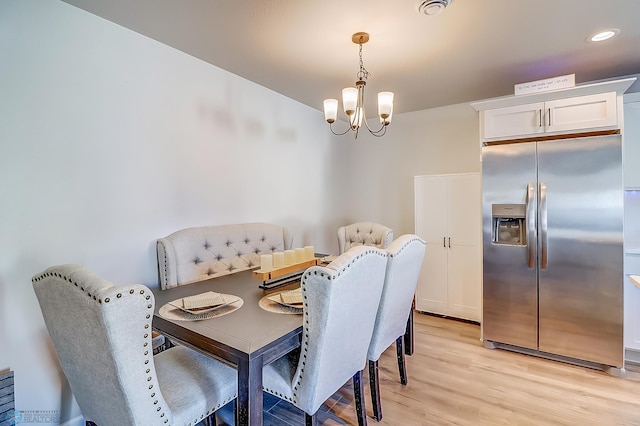 dining room with a chandelier and light wood-type flooring