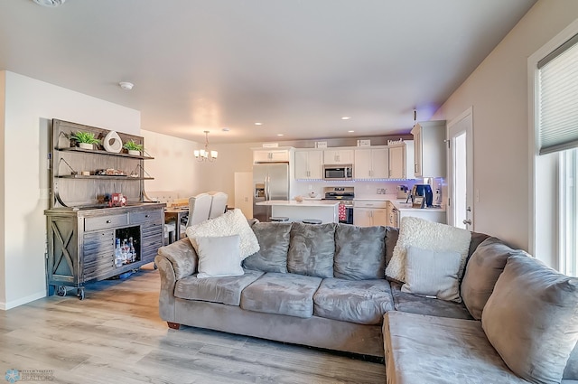 living room with an inviting chandelier and light hardwood / wood-style floors