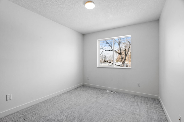 carpeted spare room featuring a textured ceiling