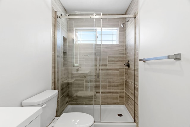 bathroom featuring walk in shower, vanity, and toilet