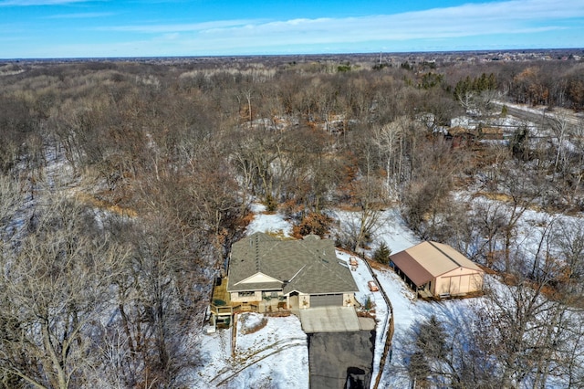 snowy aerial view with a wooded view